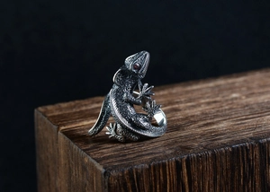 Detailed view of retro silver lizard ring featuring red eyes and intricate scale textures