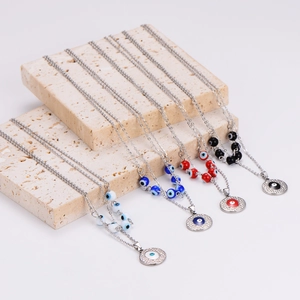 Stainless steel evil eye necklaces with colorful beads on stone display