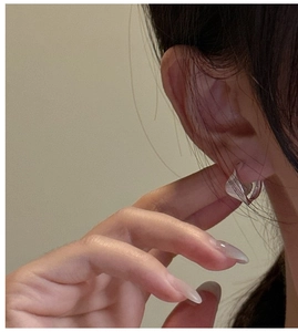 Close-up of minimalist S925 sterling silver textured hoop earring on model ear