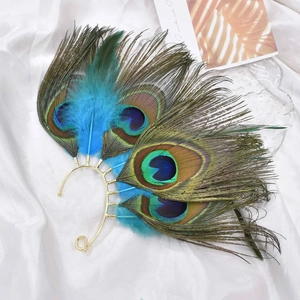 Macro detail of natural peacock feathers on a gold-tone metallic ear wrap frame