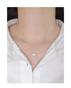 Close-up of minimalist S925 sterling silver dolphin pendant necklace on a model's collarbone
