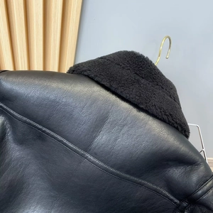 Detailaufnahme der schwarzen Lederjacke mit hochwertigem Pelzkragen und feinen Nähten