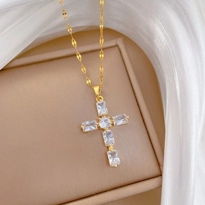 Élégant collier croix en titane doré avec zircons brillants sur fond de soie blanche