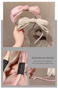 Detailed close-up of handmade satin bow headband featuring a woven quality label