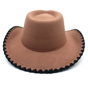 Détail d'un chapeau de cowboy en feutre marron avec des coutures noires sur le bord large