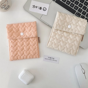Close-up of quilted heart pattern storage pouch with soft cotton texture and snap button