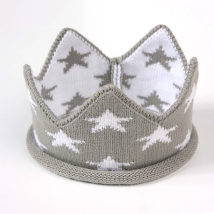 Vue détaillée du bonnet couronne tricoté pour bébé avec motifs d'étoiles et texture