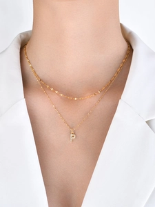 Close-up of double-layer gold necklace with sparkling P-letter pendant and texture chain