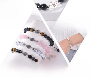 Close-up of natural tiger eye stone beads and compass charm on adjustable woven bracelet