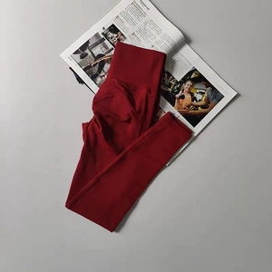 Detail of high-waist seamless compression yoga pants in dark red showing ribbed waistband