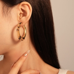Détail d'une boucle d'oreille en résine écaille avec doublure dorée sur un mannequin