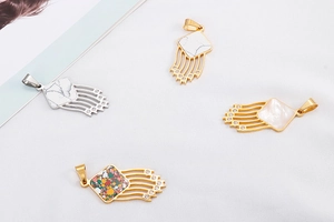 Detailed view of geometric tassel charms with rhinestones and marble stone inlays