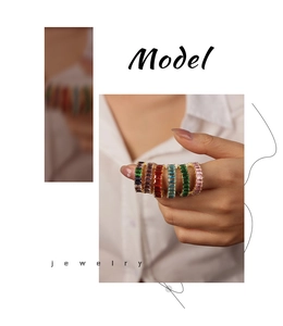 Detail of colorful emerald cut zircon rings with elegant gold plating on female hand