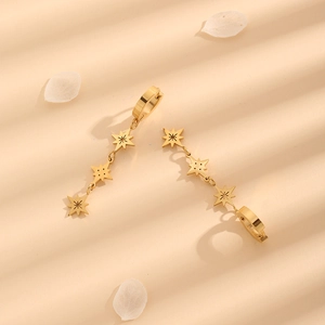 Elegant gold titanium steel star drop earrings displayed with floral petals