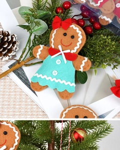 Detail of felt gingerbread girl ornament with red bow and blue dress for Christmas decor
