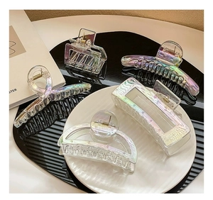 Macro detail of various geometric iridescent acrylic hair claws with aurora finish