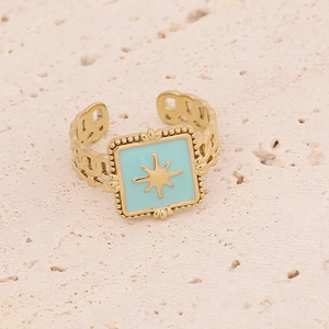 Close-up of golden ring with light blue enamel and central eight-pointed star motif