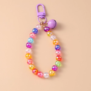 Detail of colorful transparent beaded keychain with a purple metal clasp and small bell