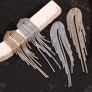 Macro detail of cascading rhinestone tassel earrings in gold and silver finishes