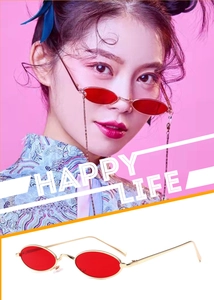 Detail of vintage oval gold metal sunglasses with transparent red lenses on female model