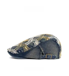 Detail view of washed denim beret with contrast stitching and vintage bronze side buckle