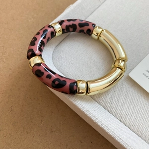 Détails de l'imprimé léopard rose et du bracelet élastique style bambou doré
