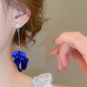 Detail of long blue petal tassel earrings with gold rod and sparkling zircon on a model