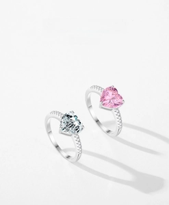 Close-up of heart-cut sparkling rings in pink and white with pavé set crystals