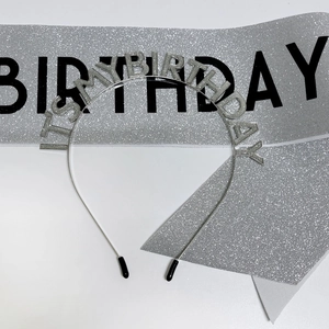 Close-up of silver glitter birthday headband with IT'S MY BIRTHDAY text and matching sash