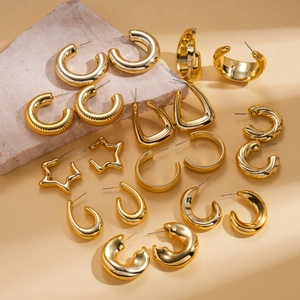 Detailed view of assorted gold geometric earrings arranged on a textured stone display