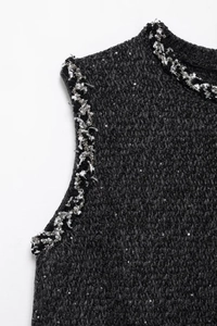 Detail of dark grey knit dress featuring silver sequins and beadwork on the shoulder