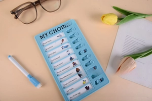 Close-up of blue children's daily chores checklist board with sliding task sliders