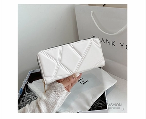 Detail of white PU leather long wallet with geometric quilted pattern and gold zipper