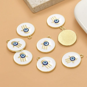 Detailed view of white enamel round Hamsa hand charms with evil eye for DIY jewelry