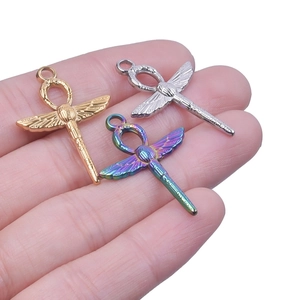 Detailed close-up of three dragonfly pendants with Egyptian Ankh cross patterns