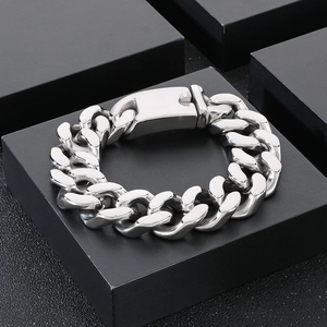 Detailed view of silver thick Cuban link bracelet with rectangular clasp on black cubes