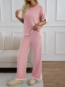 Pink knit two-piece set featuring short-sleeved top and wide-leg pants with white piping