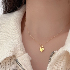 Minimalist gold heart padlock necklace with for.me engraving worn by a model