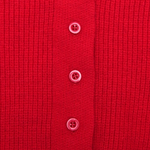 Detailed close-up of vibrant red ribbed knit fabric with three matching color buttons