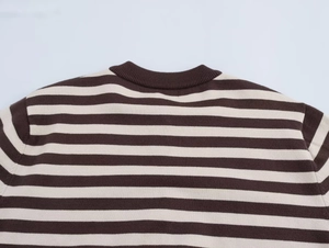 Detail of crew neck and shoulder on a striped brown and cream knit sweater