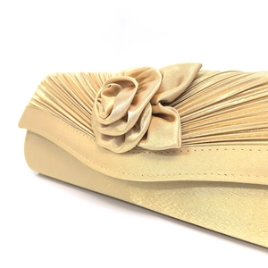 Detail view of champagne gold satin evening clutch with handmade pleated fabric flower