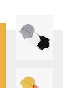 Detail view of ribbed knit beanies in gray, white, black, yellow and orange colors
