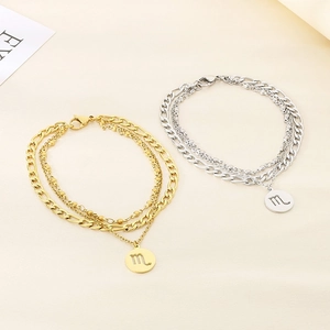 Vue détaillée de pendentifs Scorpion sur des chaînes de cheville multicouches or et argent