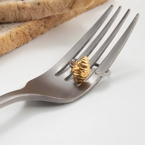 Détail de la bague croissant dorée sur une fourchette montrant les textures réalistes