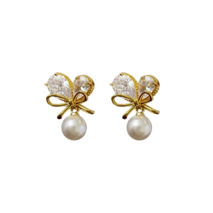 Elegante goldene Schleifenohrringe mit Herzkristallen und weißen Perlen auf weiß
