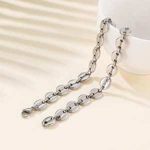 Elegant silver stainless steel coffee bean link necklace draped over a ceramic vase