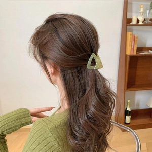 Elegant green triangular hair claw clip worn in a high ponytail hairstyle for women