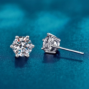 Detail of classic six-prong silver stud earrings featuring round brilliant cut moissanite stones