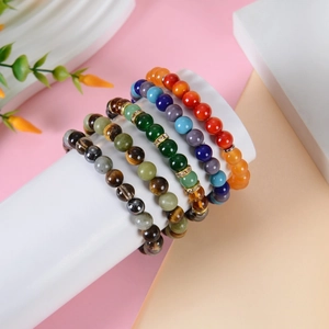 Tiger eye and citrine beaded bracelet set on a white podium with floral accents