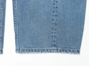 Detaillierte Nahaufnahme von hellblauem Jeanssaum mit Twill-Textur und feinen Nähten